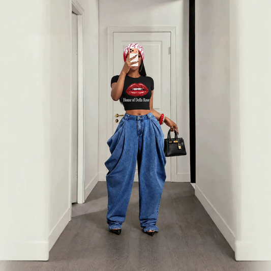 Original model wearing blue pleated jeans, House of Della Rose glitter-lips tee, black heels and black purse